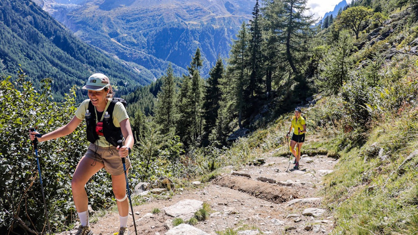 runners with poles in the alps