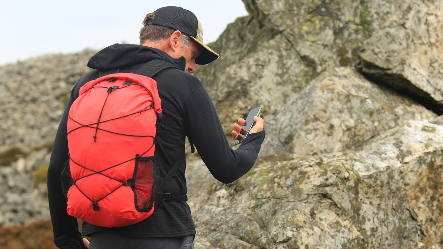 Hiker wearing the alpkit gourdon waterproof backpack