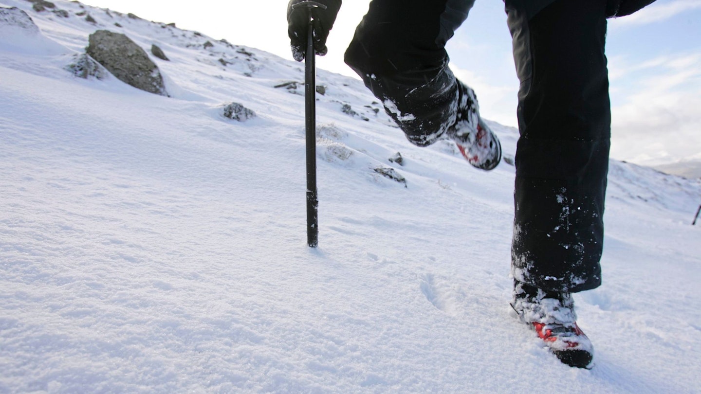 Kicking steps in snow hiking in mountains