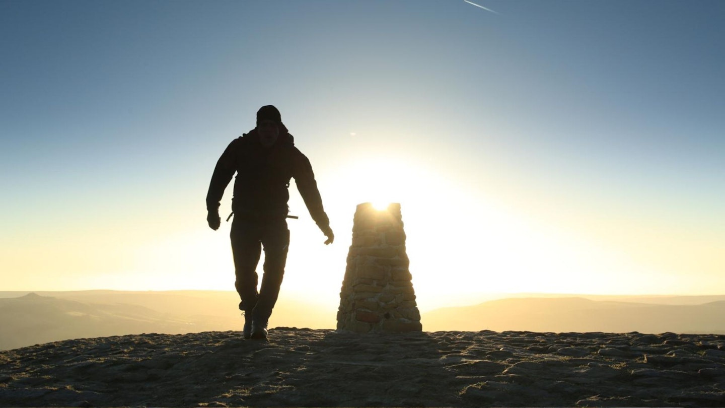 Hiker at Sunrise on the summit of Mam Tor, Peak District