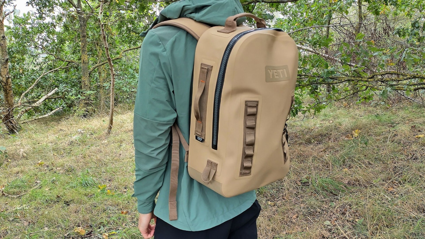 Hiker wearing YETI Panga 28L Waterproof Backpack