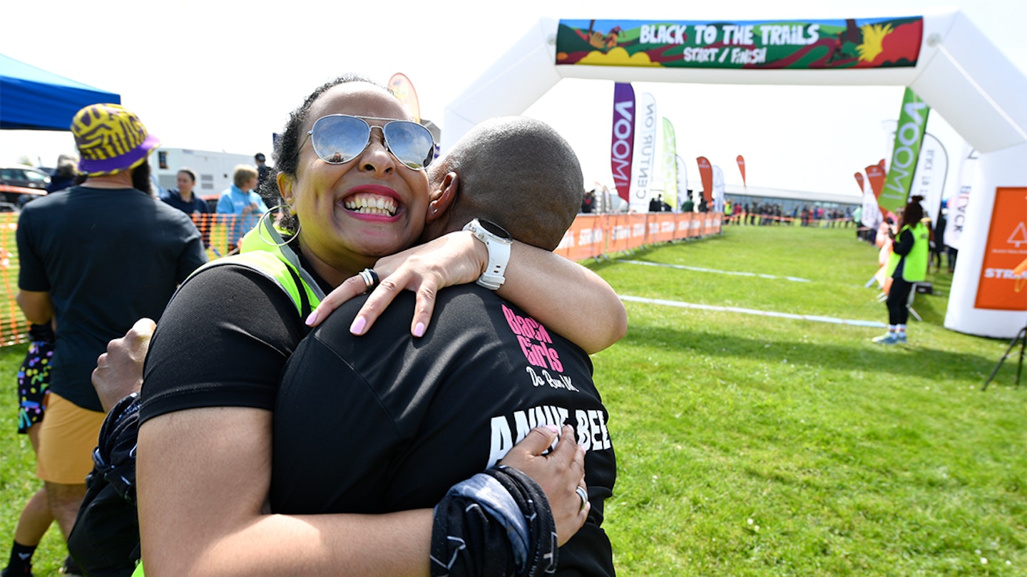 black to the trails race two runners hug