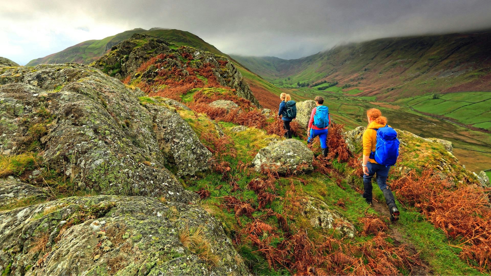 Three hikers in the rain with backpacks
