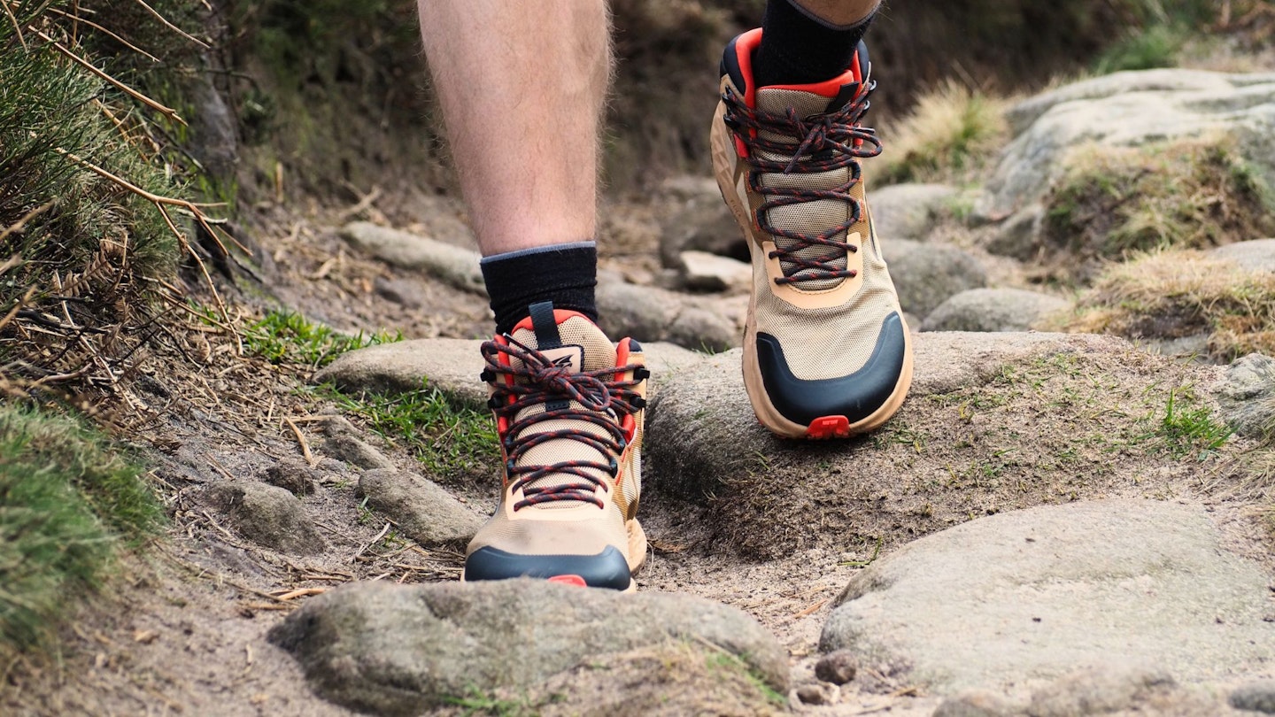 Walking down a rocky path wearing Altra Timp Hiker