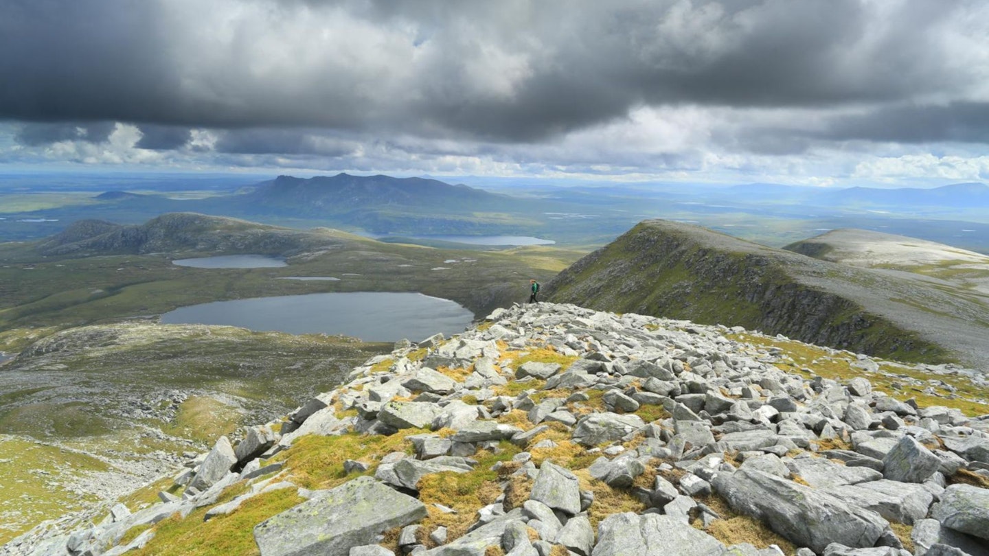 Ben Loyal in the distance with a hiker heading from the summit of Ben Hope in Sutherland