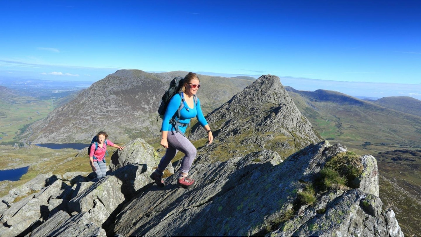 Female hikers on Bristly Ridge Glyder Fach Tryfan behind Snowdonia. One of the best hikes in the UK