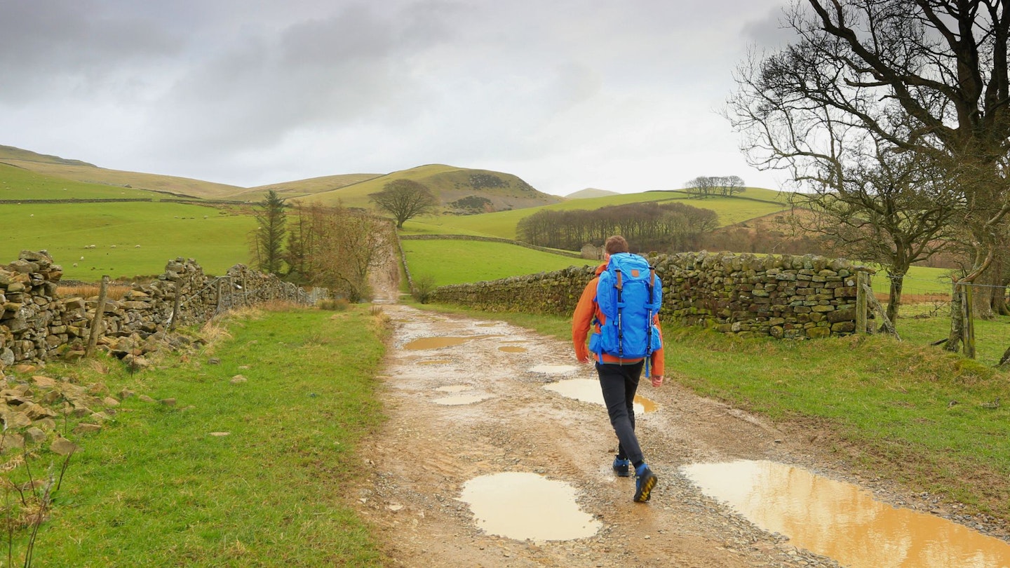 Chris Williams walking down a country lane while testing Fjällräven Kajka 55