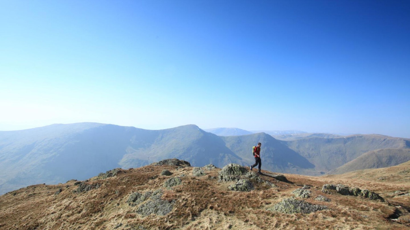 Walker on Kentmere Pike Summit looking West to Yoke Ill Bell Froswick Kentmere Horseshoe Lake District