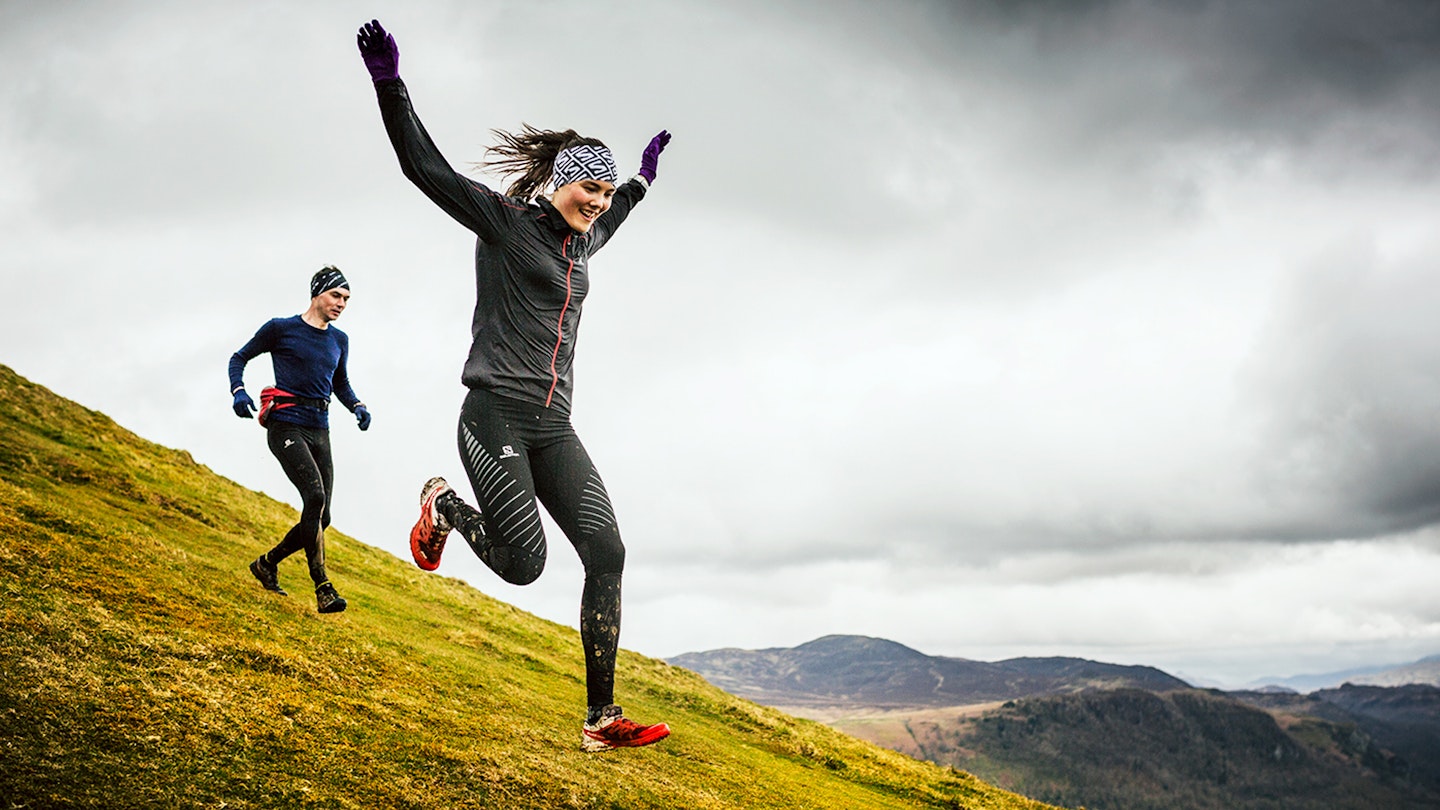 Runners heading down a grassy hill