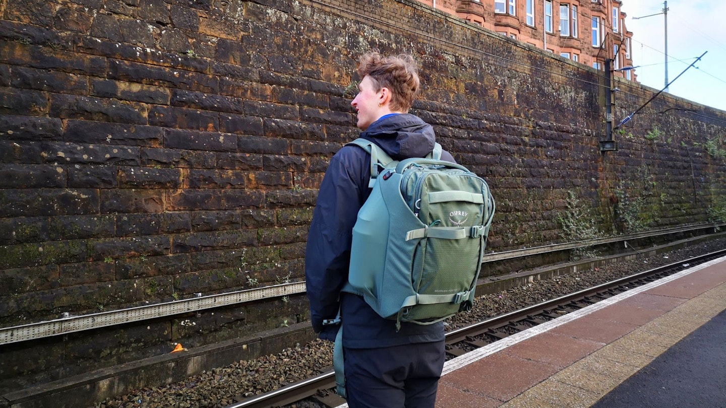 Ben wears the bag at a train station