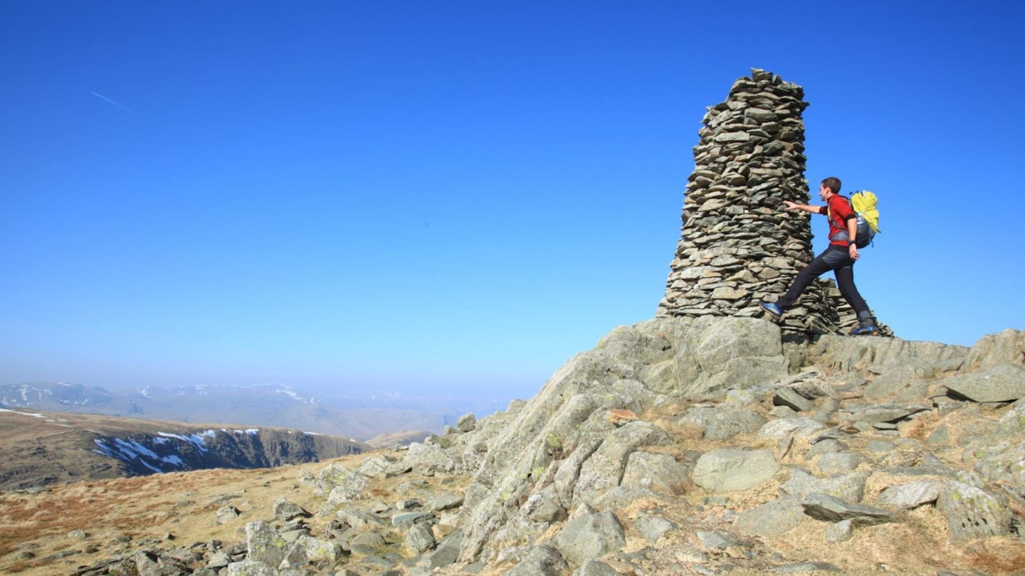 Walker at Thornthwaite Crag Beacon on the Kentmere Horseshoe in the Lake District