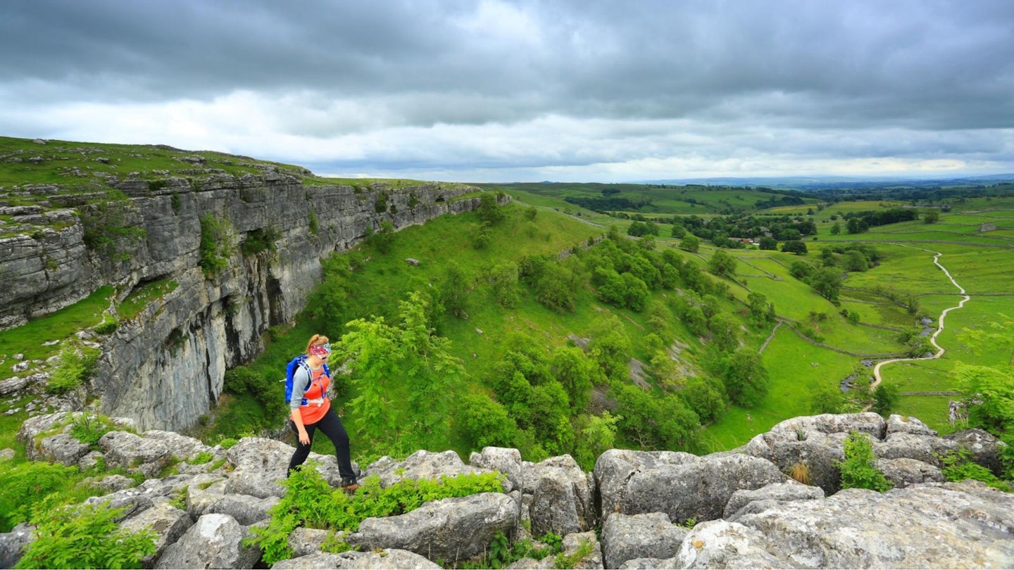 Walking on the limestone pavement at Malham, Yorkshire Dales. Part of the Malham Cove and Gordale Scar walking route
