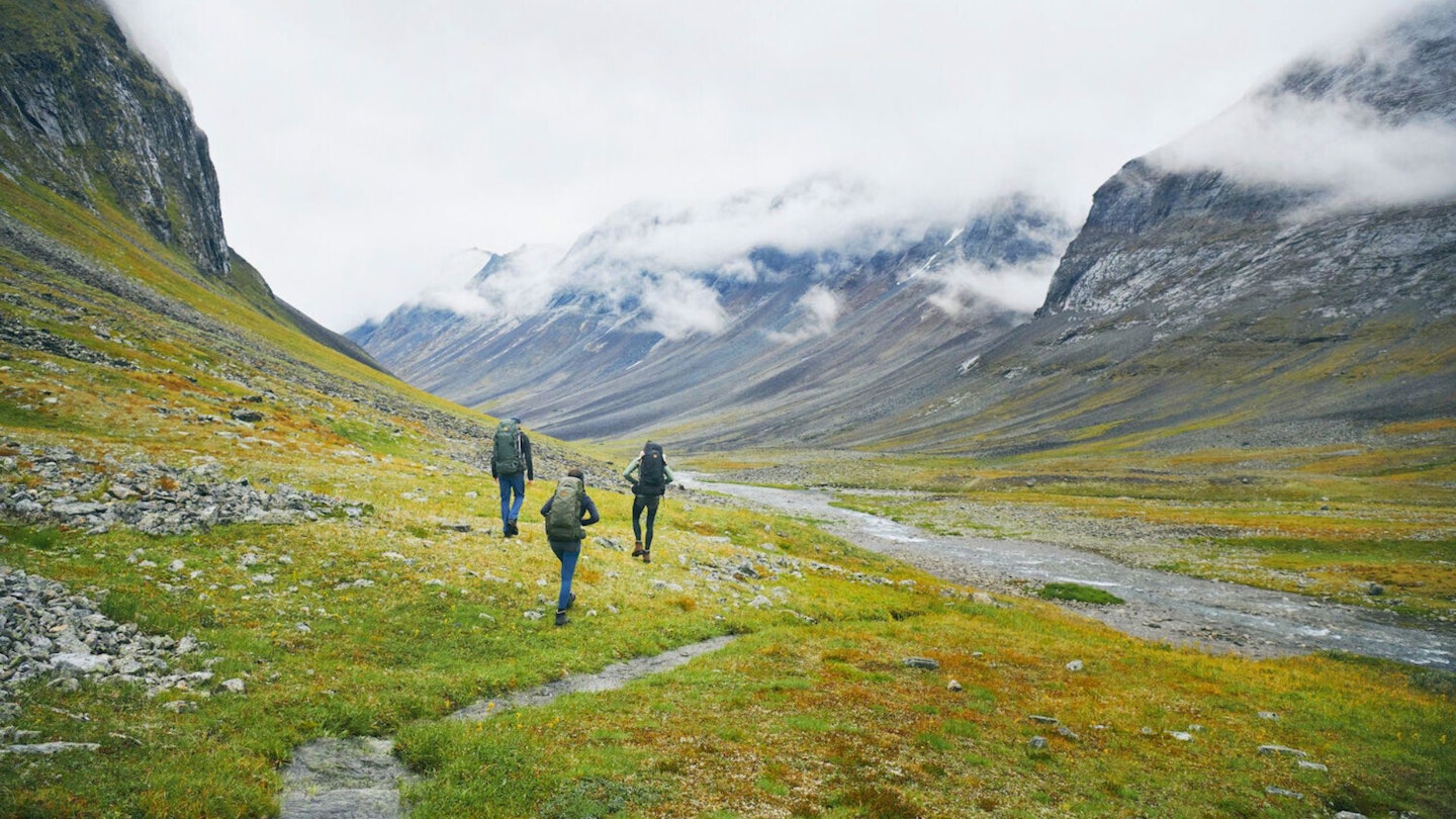 Three hikers in a valley in Sweden