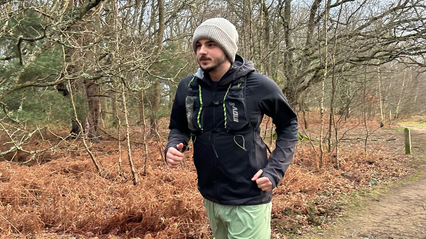trail runner wearing the inov8 performance hybrid jacket and race vest