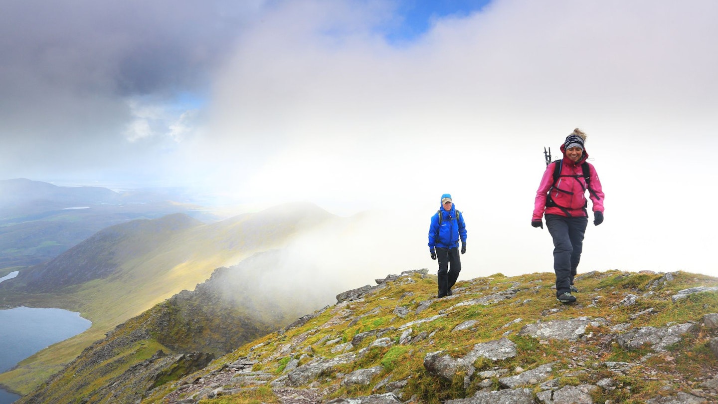 two people walk uphill testing waterproof jackets