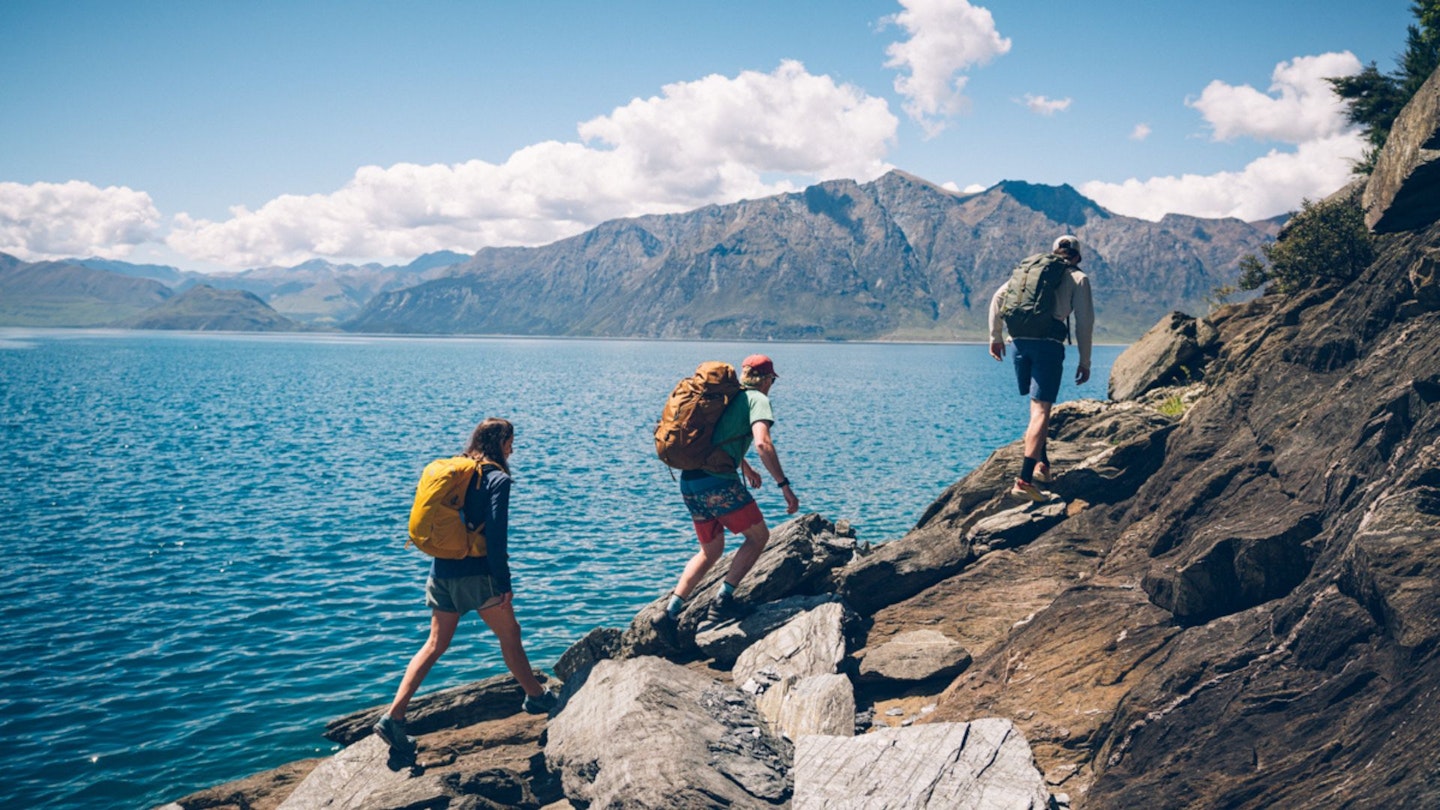 Hikers on a coastal trail wearing Gregory backpacks. Best women's backpacks