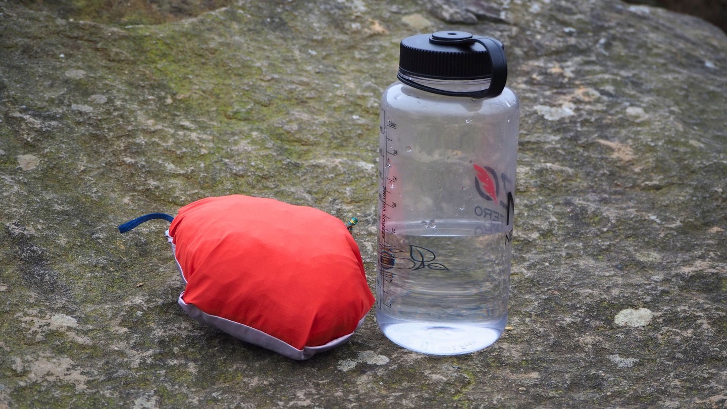 Patagonia Storm Racer Waterproof Jacket in stash pocket next to drink bottle for scale