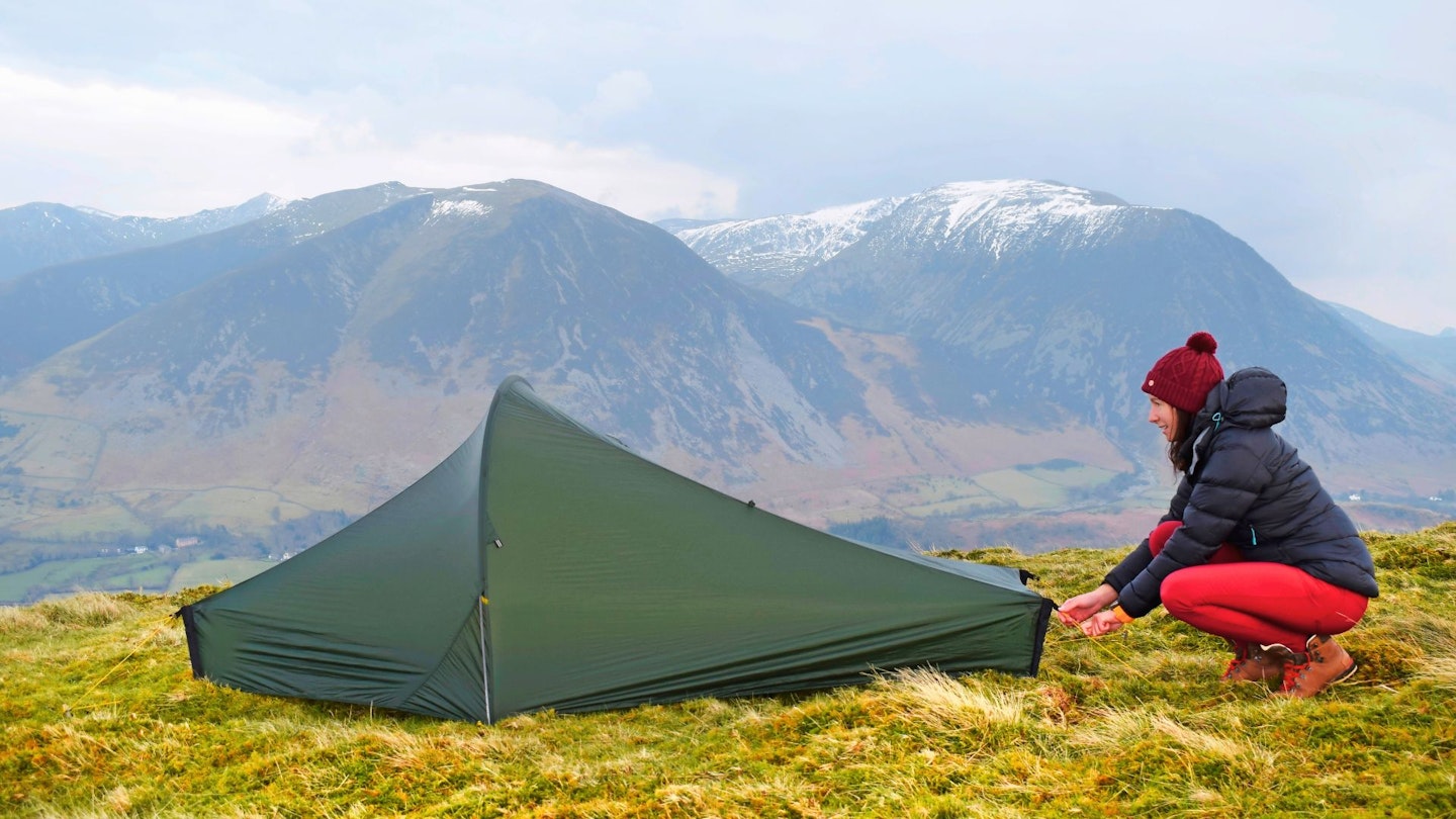 Hiker pitching Nordisk tent in the mountains