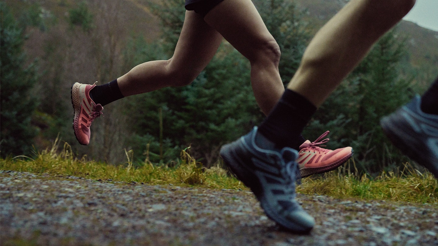 runners legs on a gravel path with inov8 trailfly shoes on