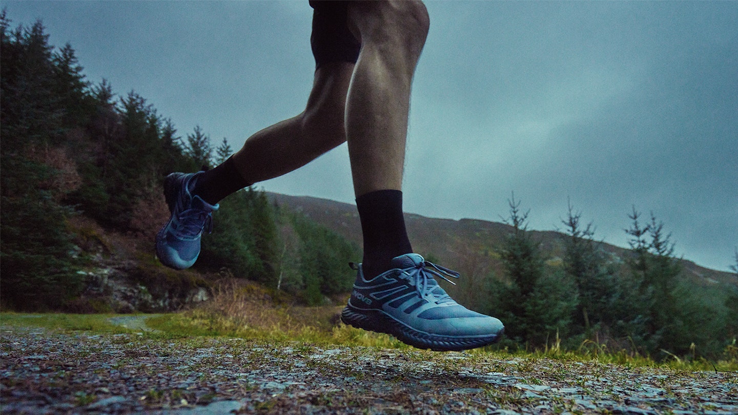the inov8 trailfly trail running shoes running on a rocky track