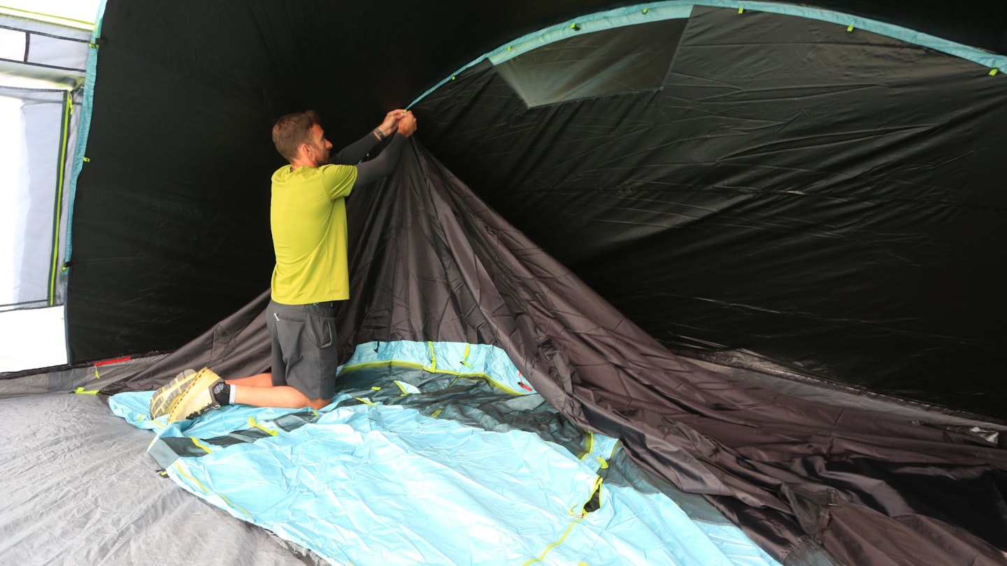 Person putting up inner bedroom of Coleman Meadowood 6L BlackOut Tent