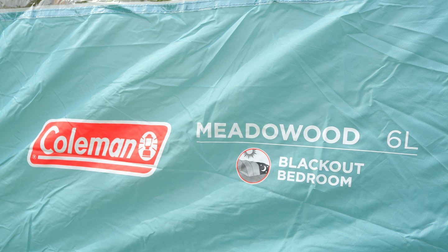 Closeup of Coleman Meadowood 6L BlackOut Tent logo and model printed on tent fabric