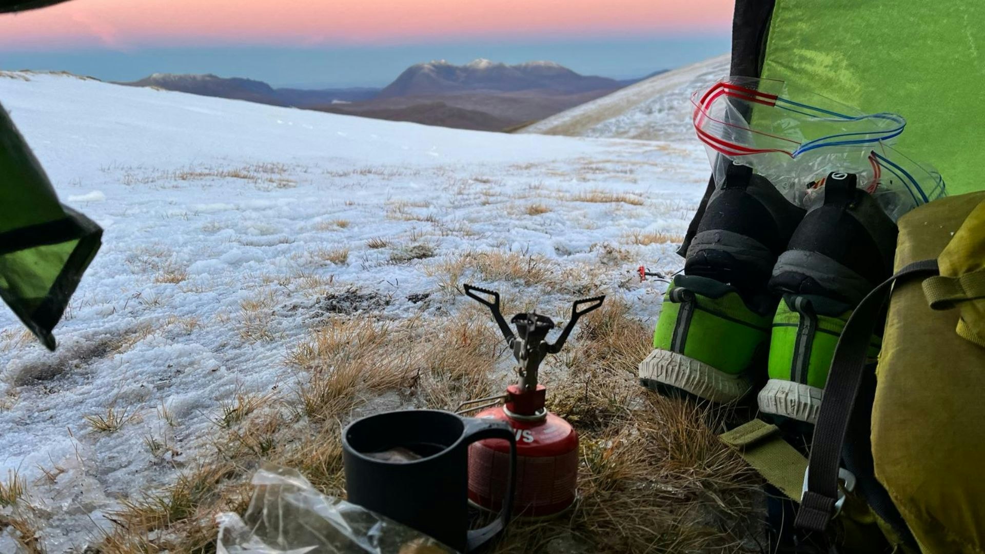 Stove overlooking a cold and windy hilltop from the door of a tent