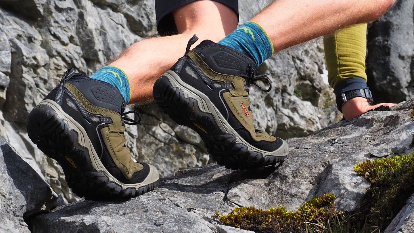 Hiker scrambling up a rock wearing KEEN Targhee IV boots