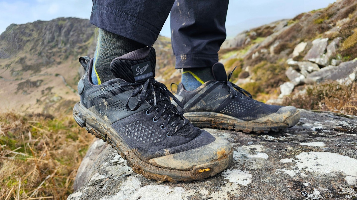 Closeup of hiker standing on a rock wearing Danner Trail 2650 GTX, flexing the shoe