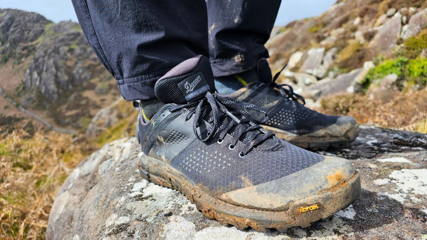 Closeup of hiker standing on a rock wearing Danner Trail 2650 GTX, right side view