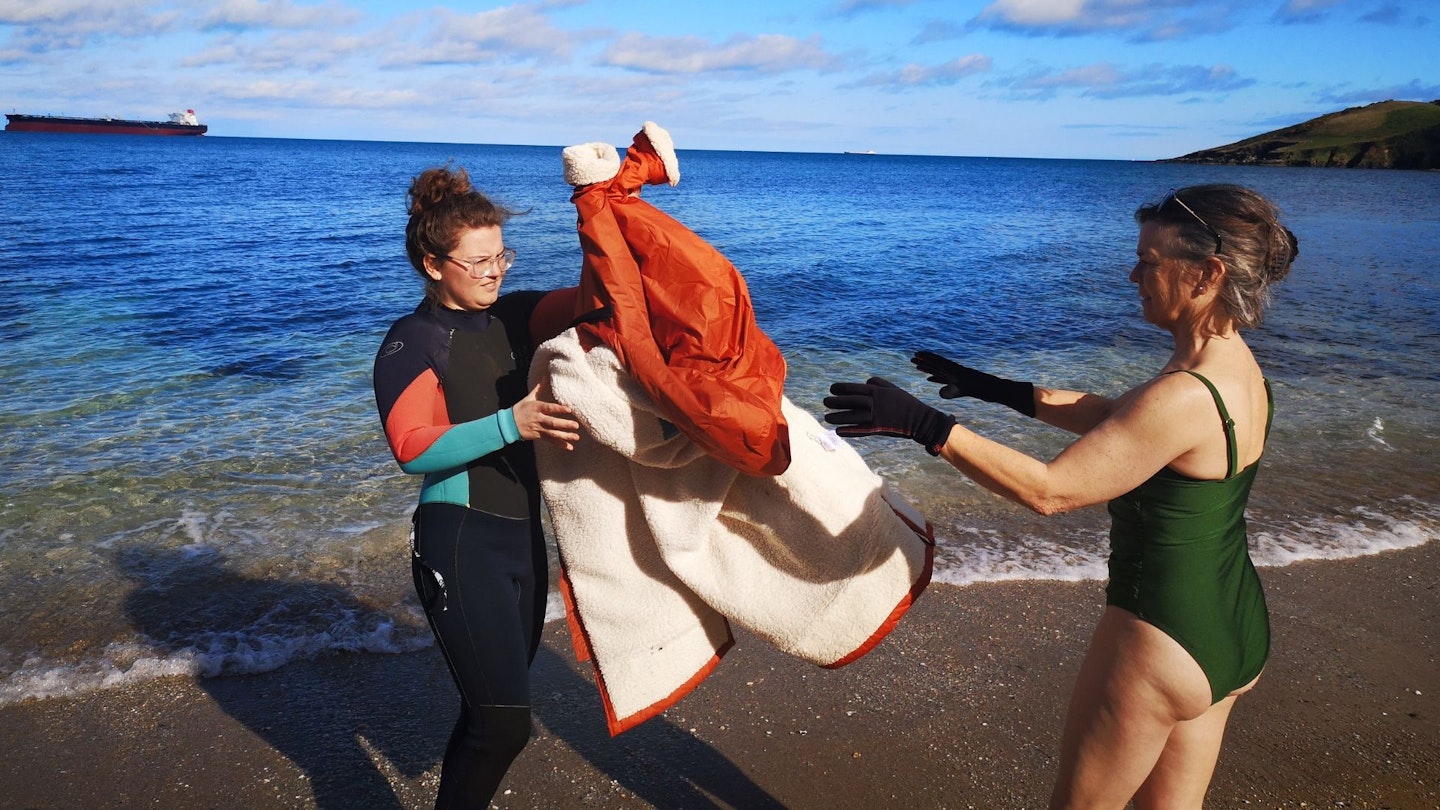 Fliss hands her mother a passenger dryrobe for coming out of the sea