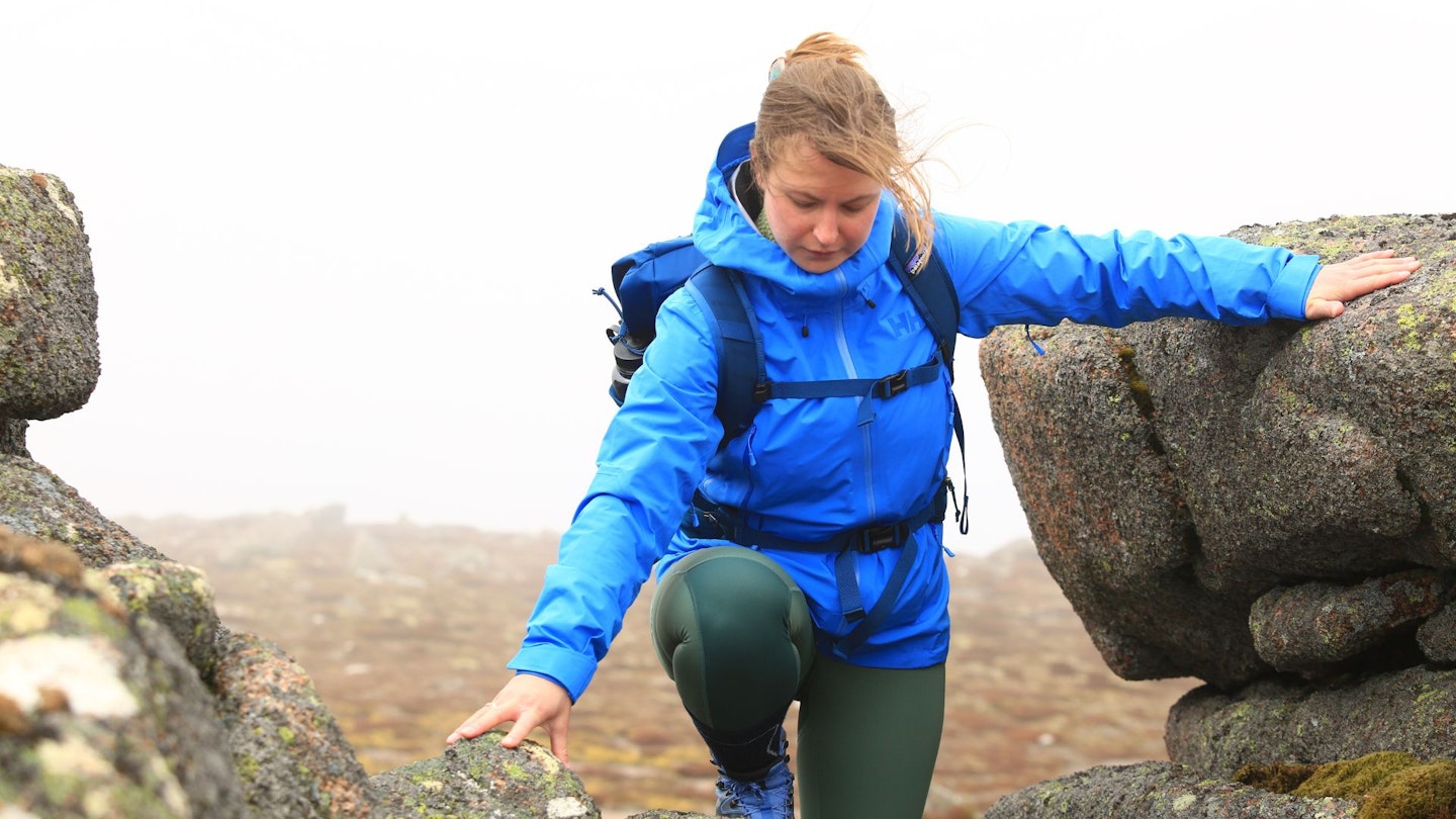 Hiker climbing rocks wearing Helly Hansen Verglas Infinity Shell Jacket