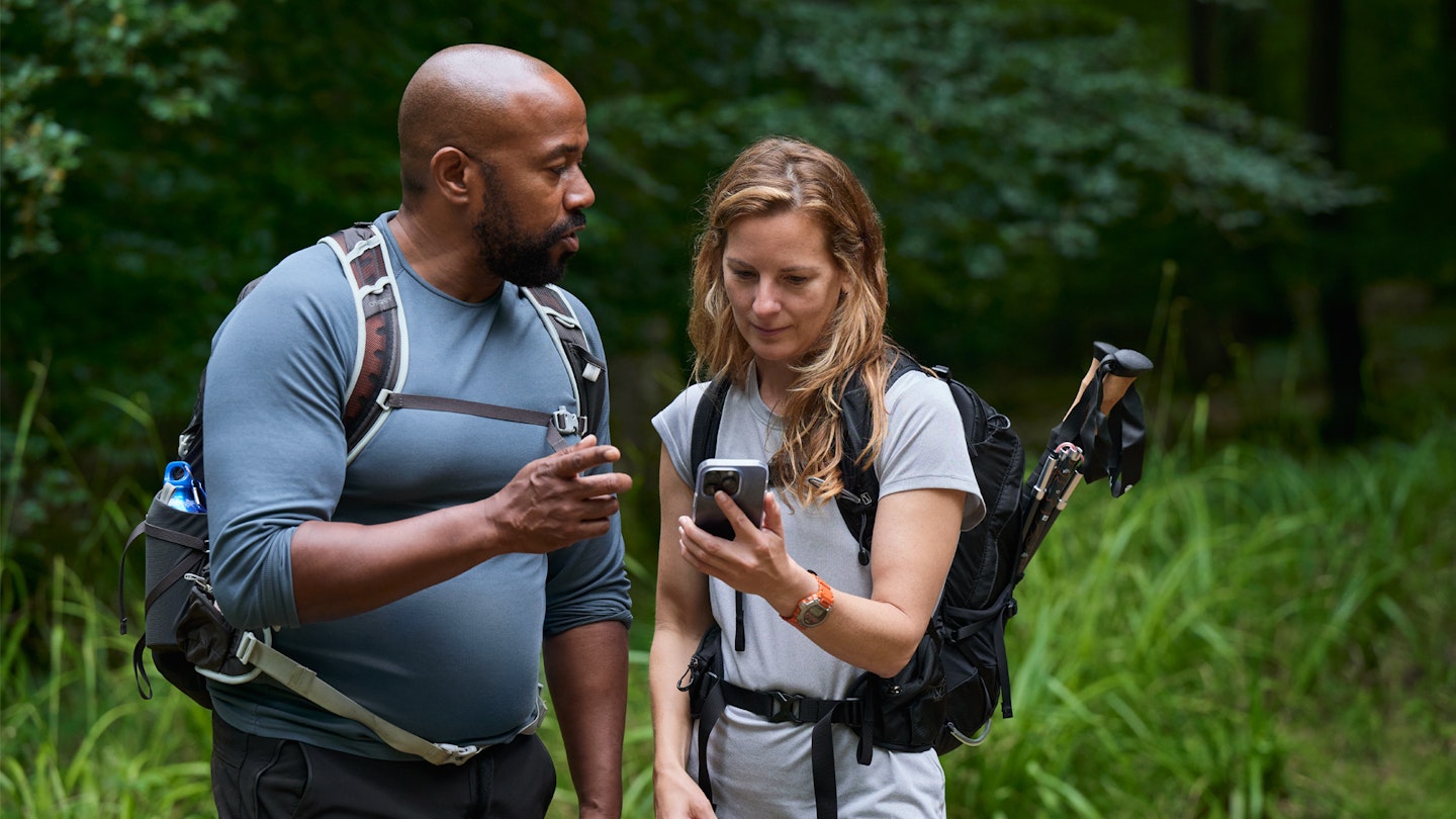 Hikers checking an OS Maps app on a phone