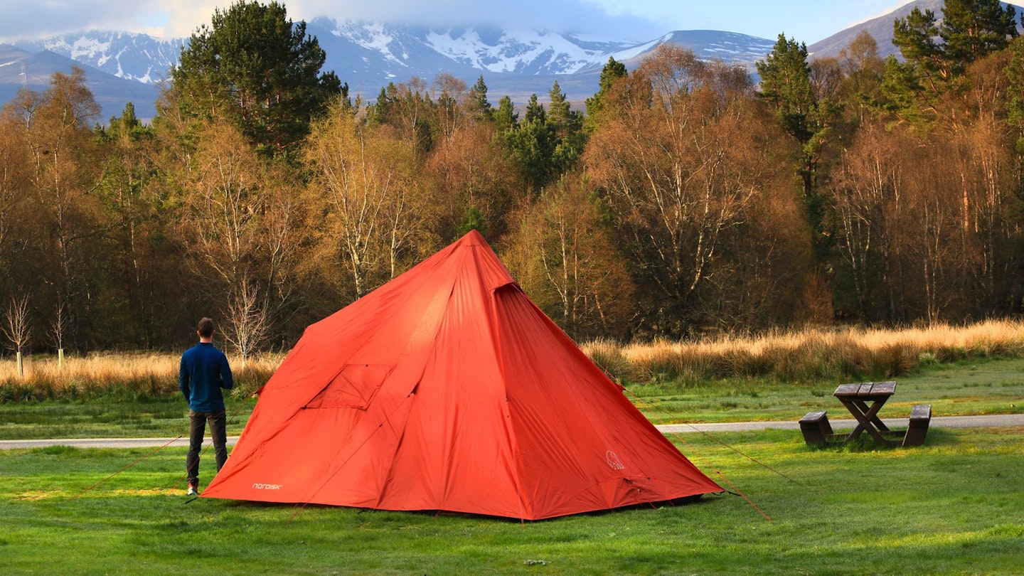 LFTO tester standing next to Nordisk Thrymheim 5 PU tent, looking at mountains