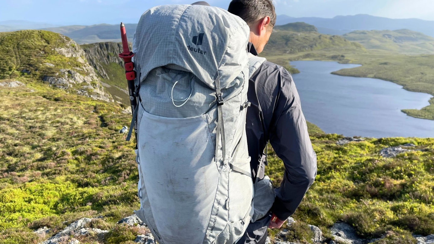 Hiker putting on Deuter Aircontact Ultra 50+5