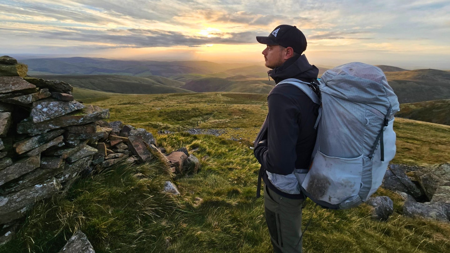 At sunset on a hill, Matt Jones wearing Deuter Aircontact Ultra 50+5