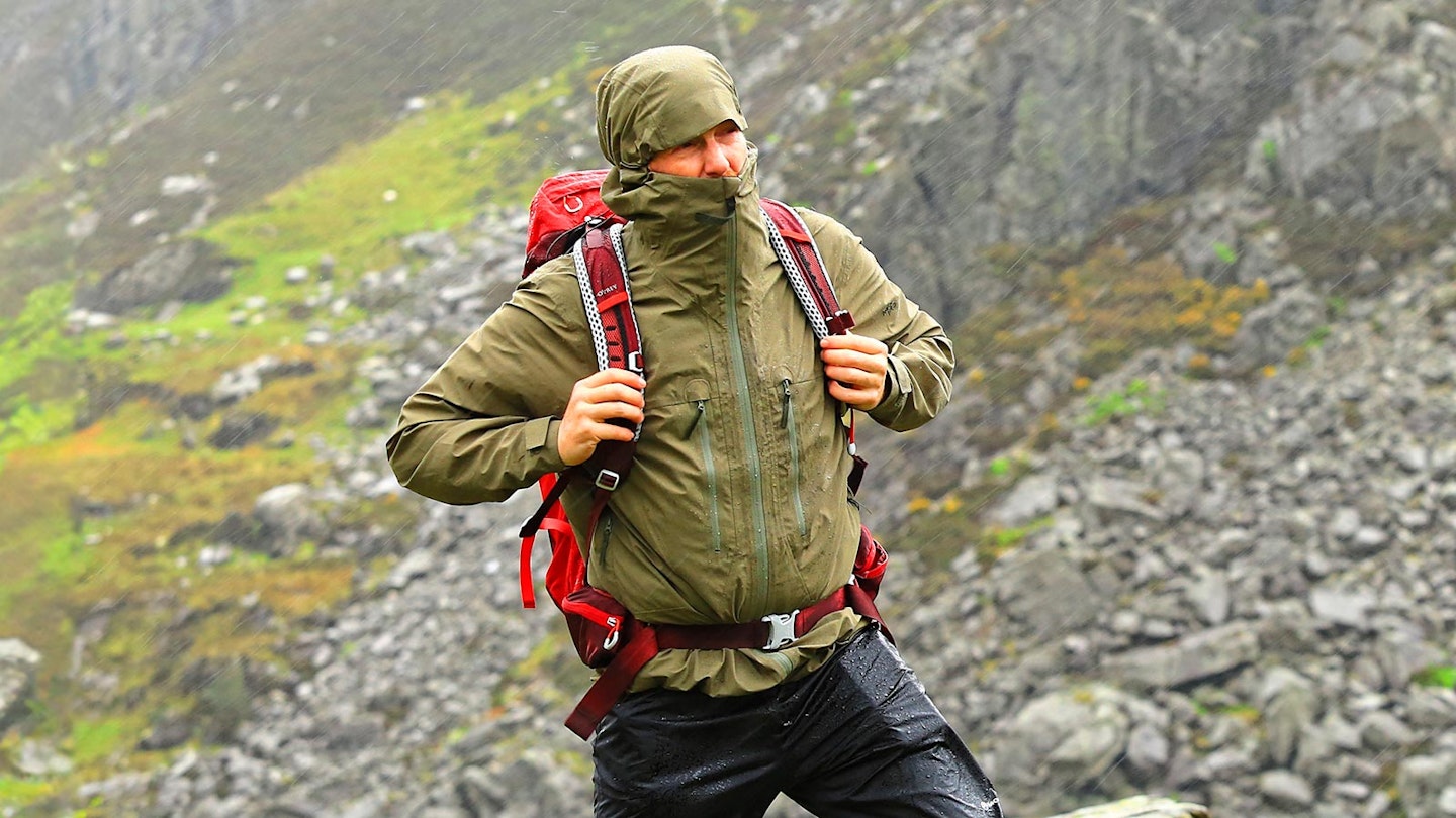 Man wearing StormMove Lightweight waterproof jacket in the rain in the mountains