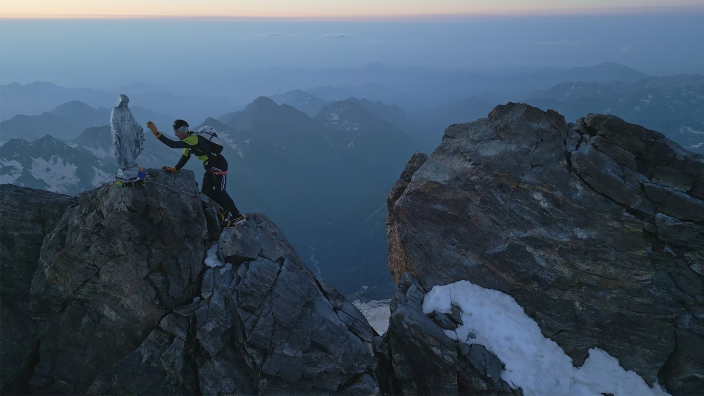 Alex Steindl reaching a summit on alpine peaks of the Spaghetti tour