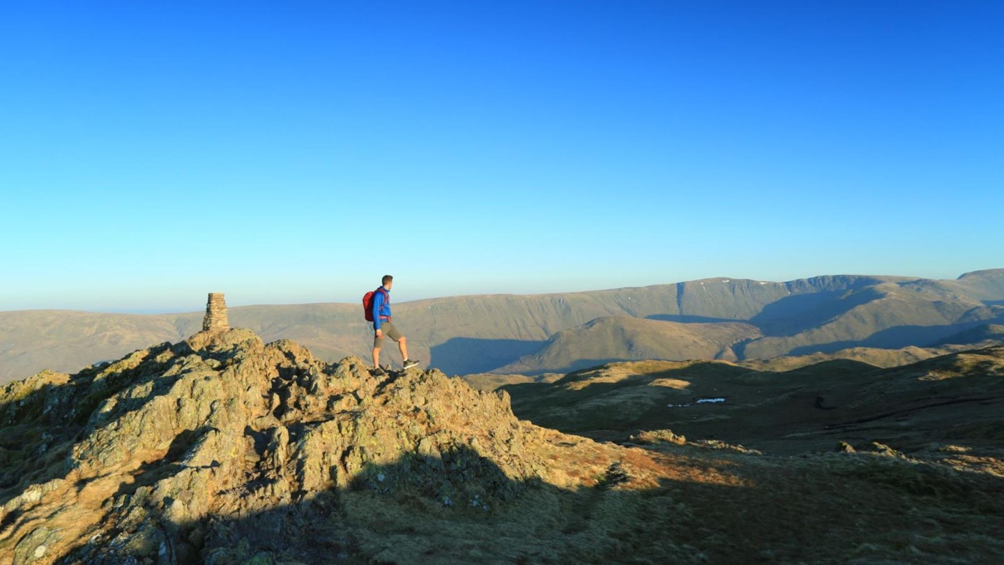 Hiker on Place Fell summit, looking to High Street Lake District