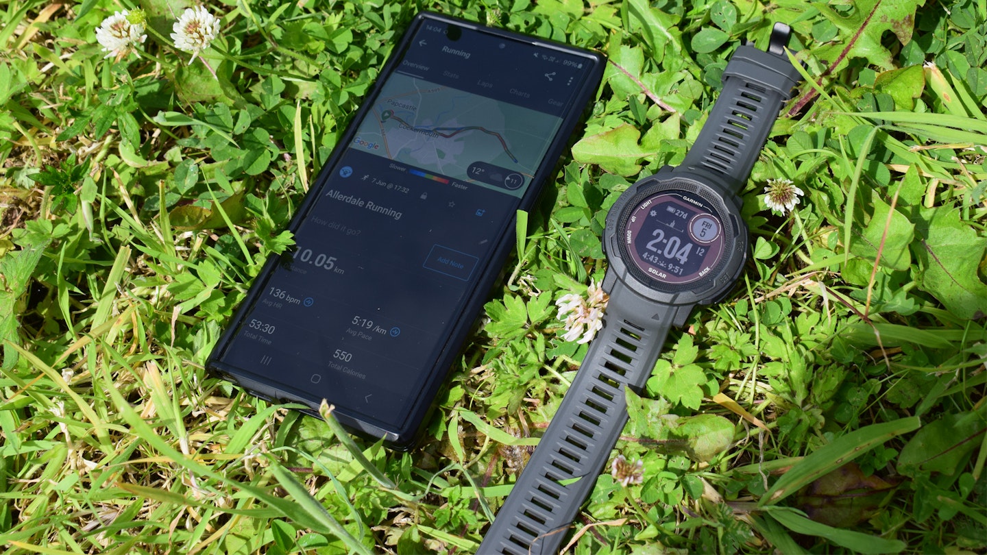 the Garmin Instinct 2 solar GPS running watch connected to a phone