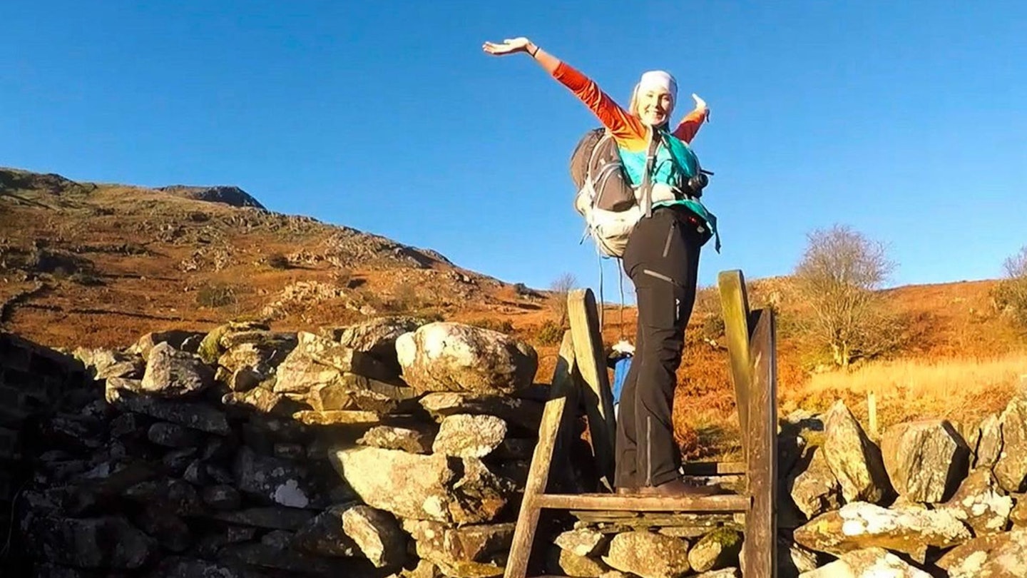 Hannah James climbing a stile on to Moel Hebog Snowdonia