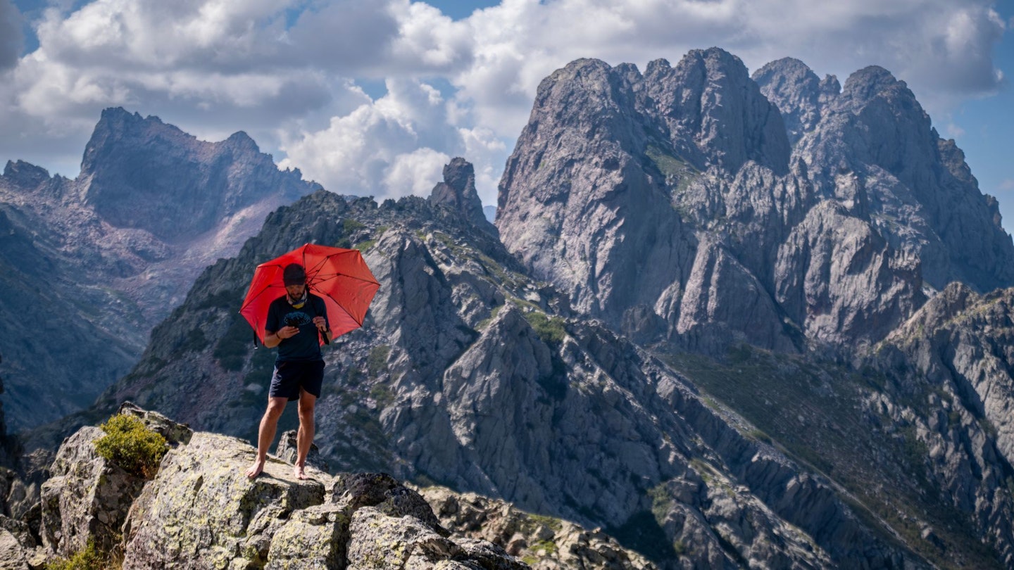 Corsica GR20 Day 3 hiker with umbrella shielding from sun