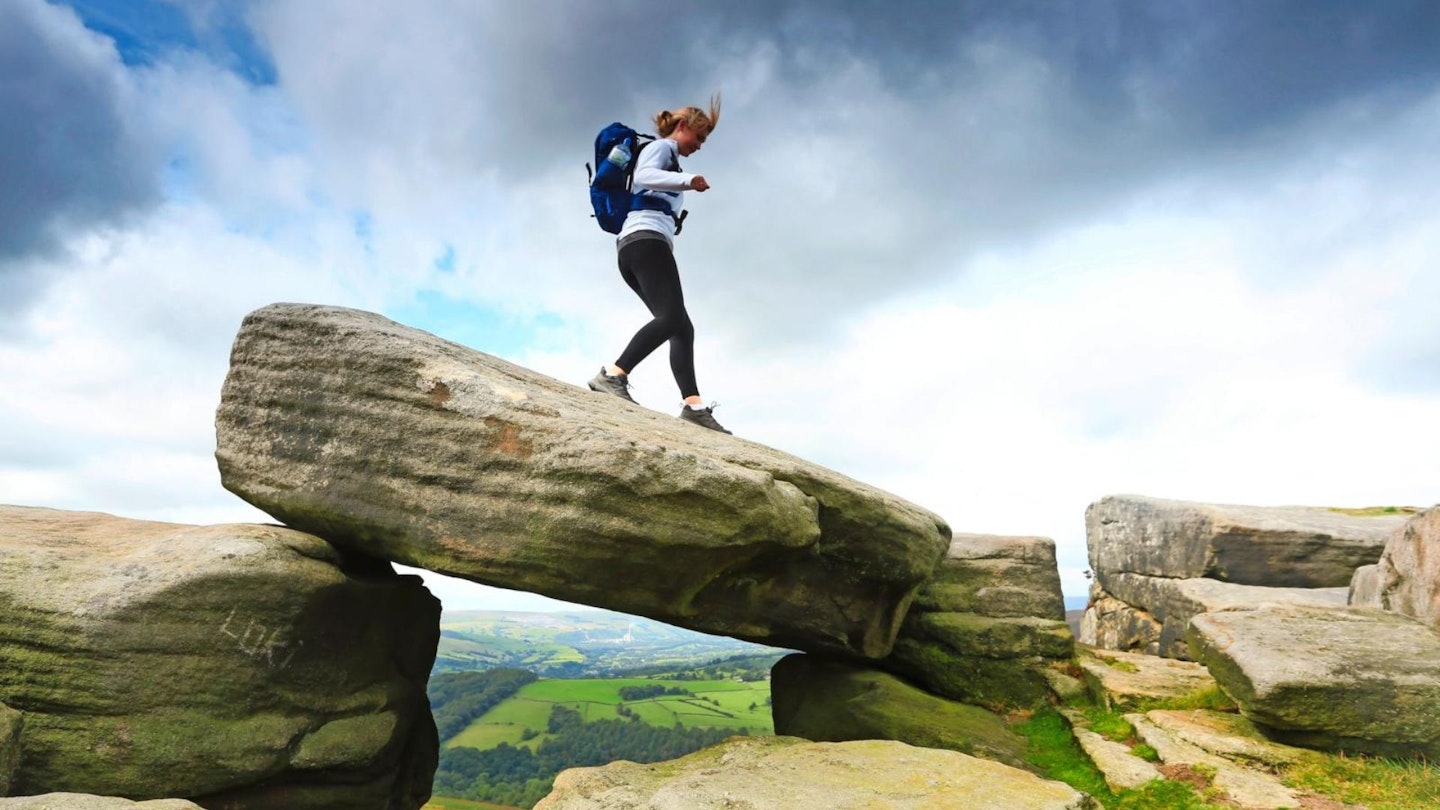 Female hiker on Stanage Edge rocks Peak District