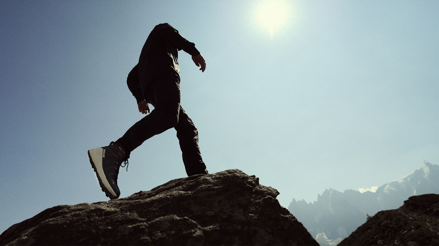 Hiker on a rock wearing the inov8 roclite pro walking boot