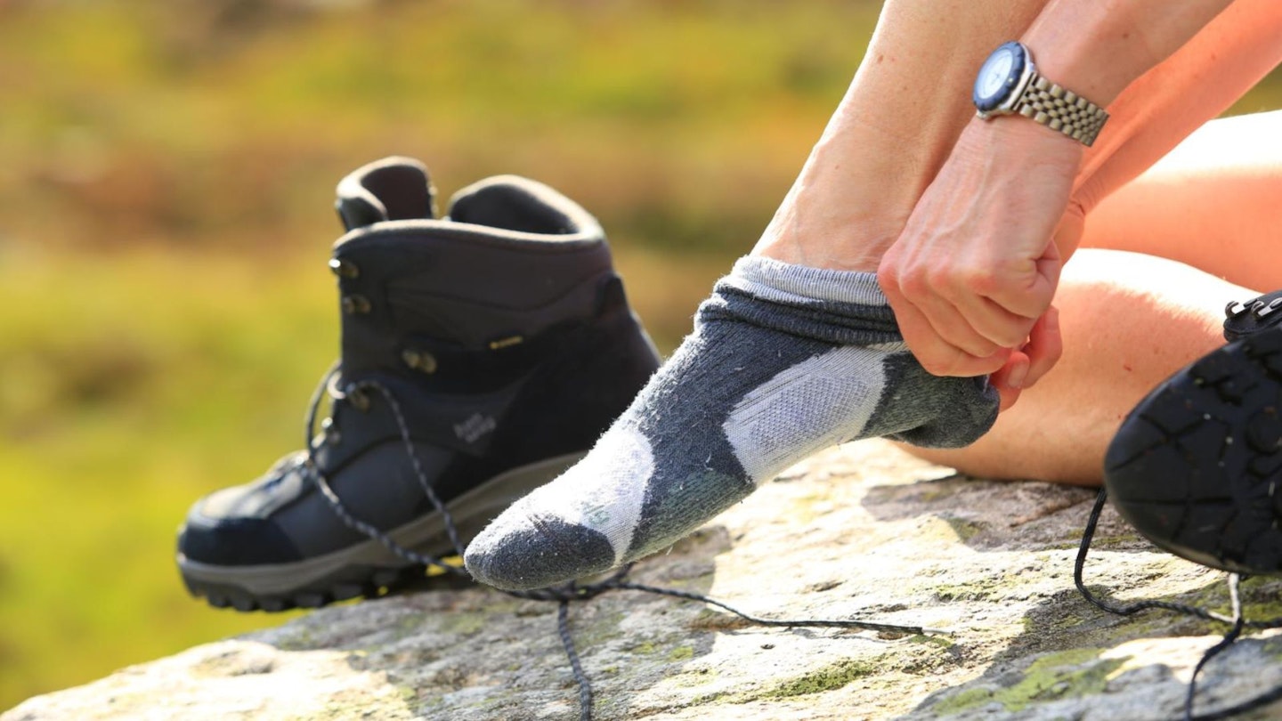 Hiker pulling on Bridgedale socks