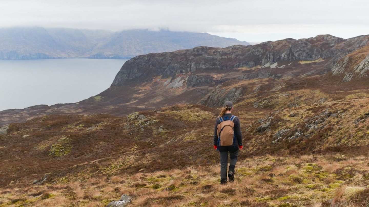 Woman descending on eigg wearing walking trousers