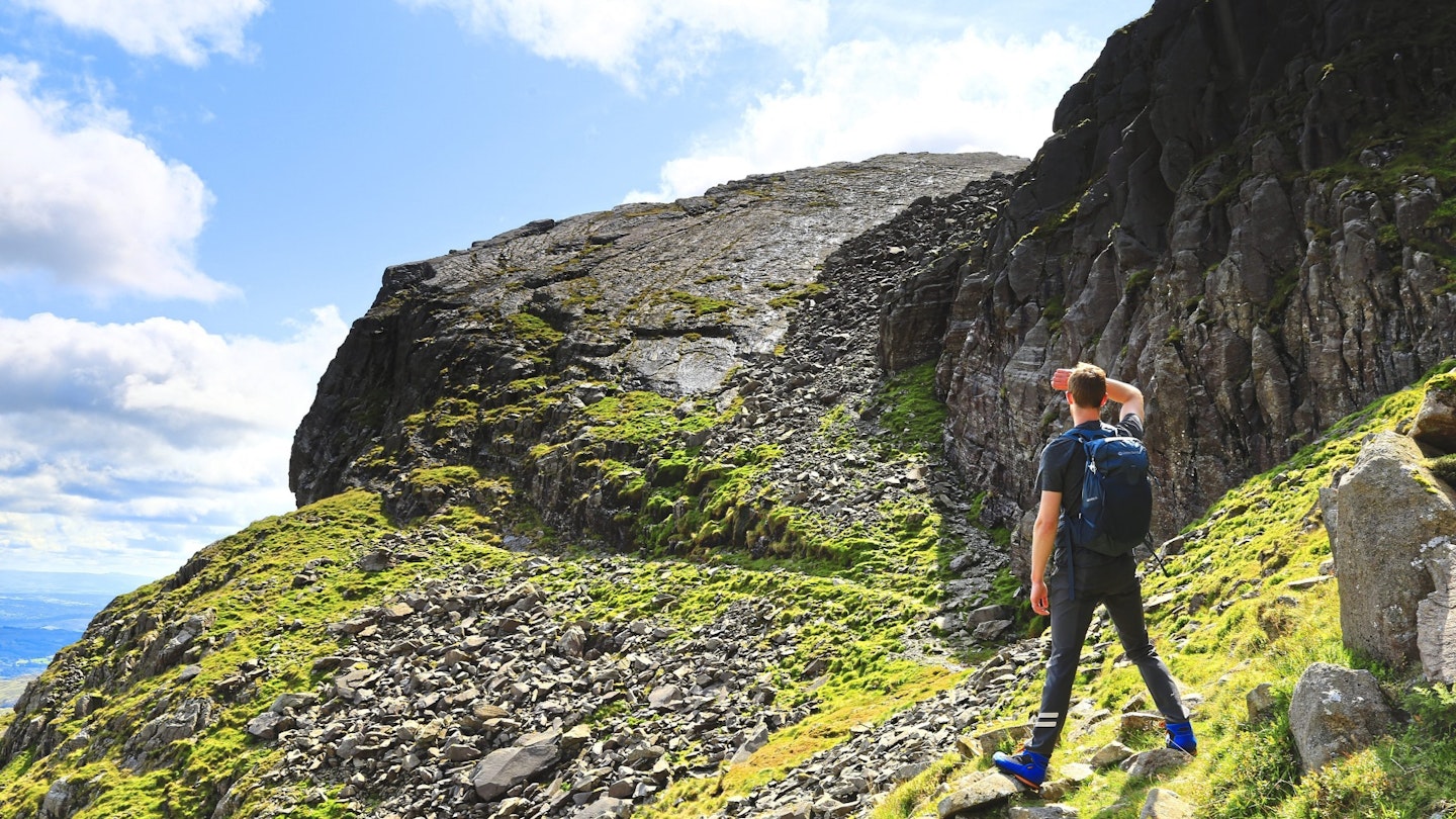 Hiker looking at Bow fell Great Slab, Lake Great Slab