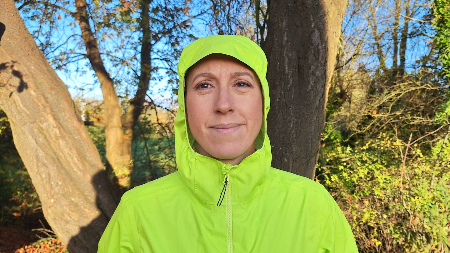 hood up on the Janji Rainrunner waterproof jacket