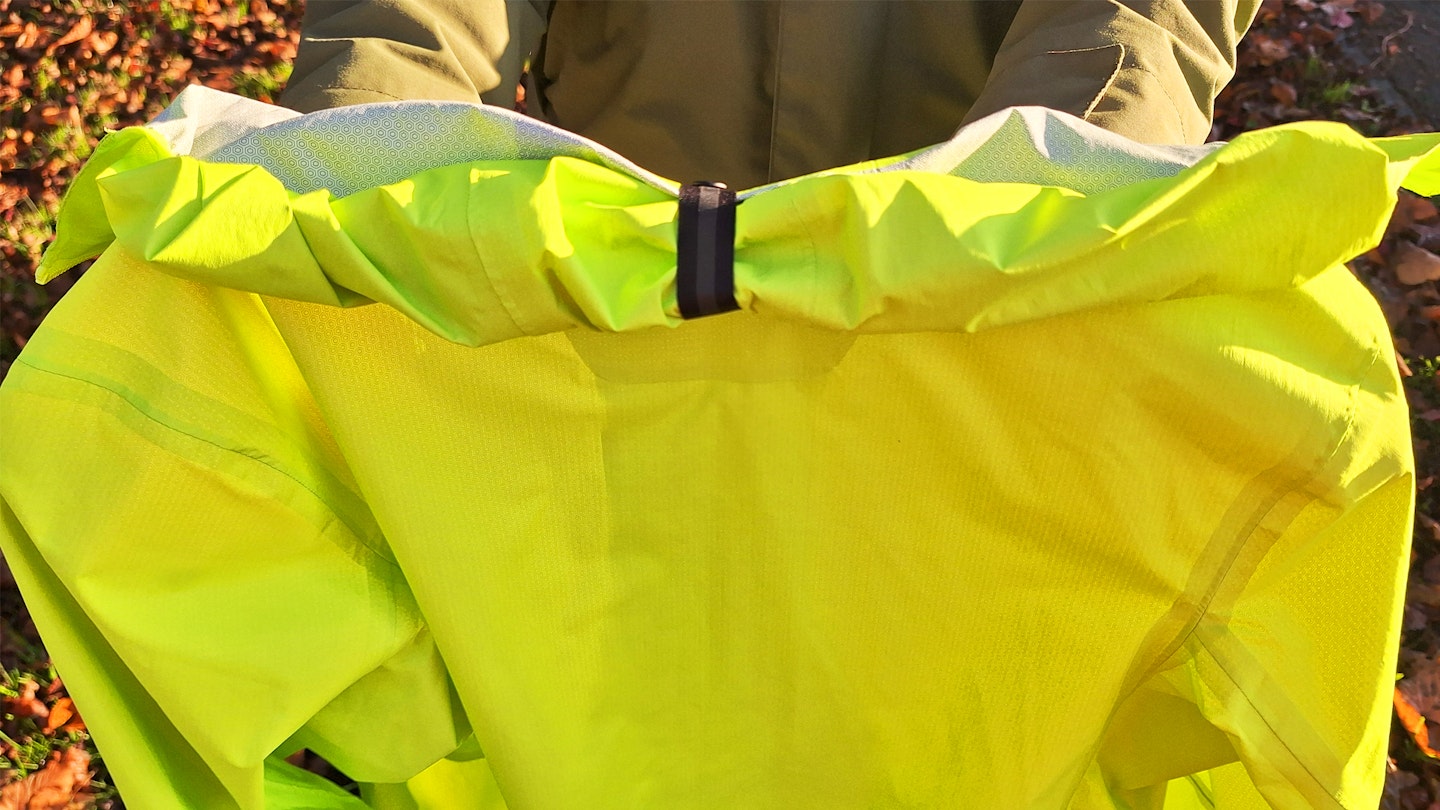 rolled down hood of the Janji Rainrunner waterproof jacket