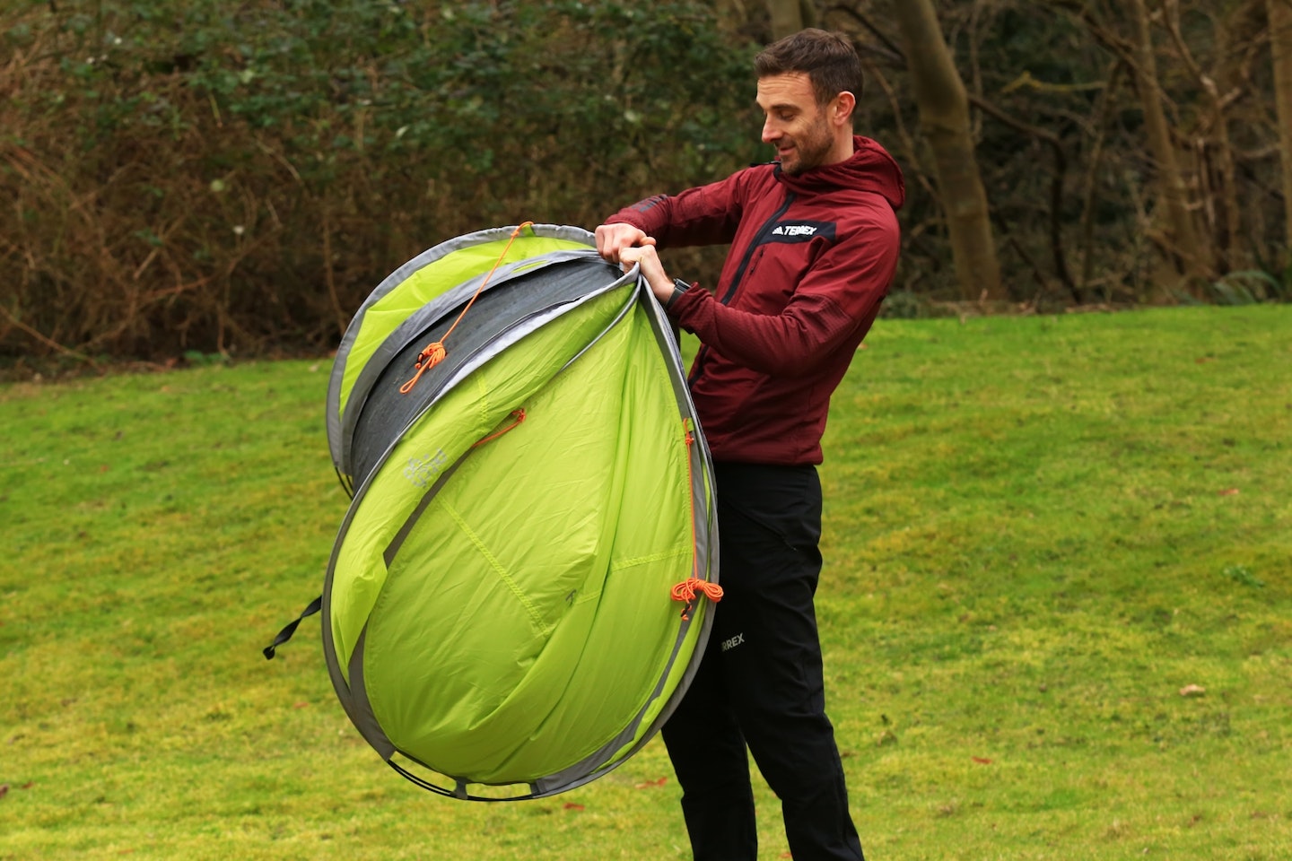 Holding a pop-up tent on the side